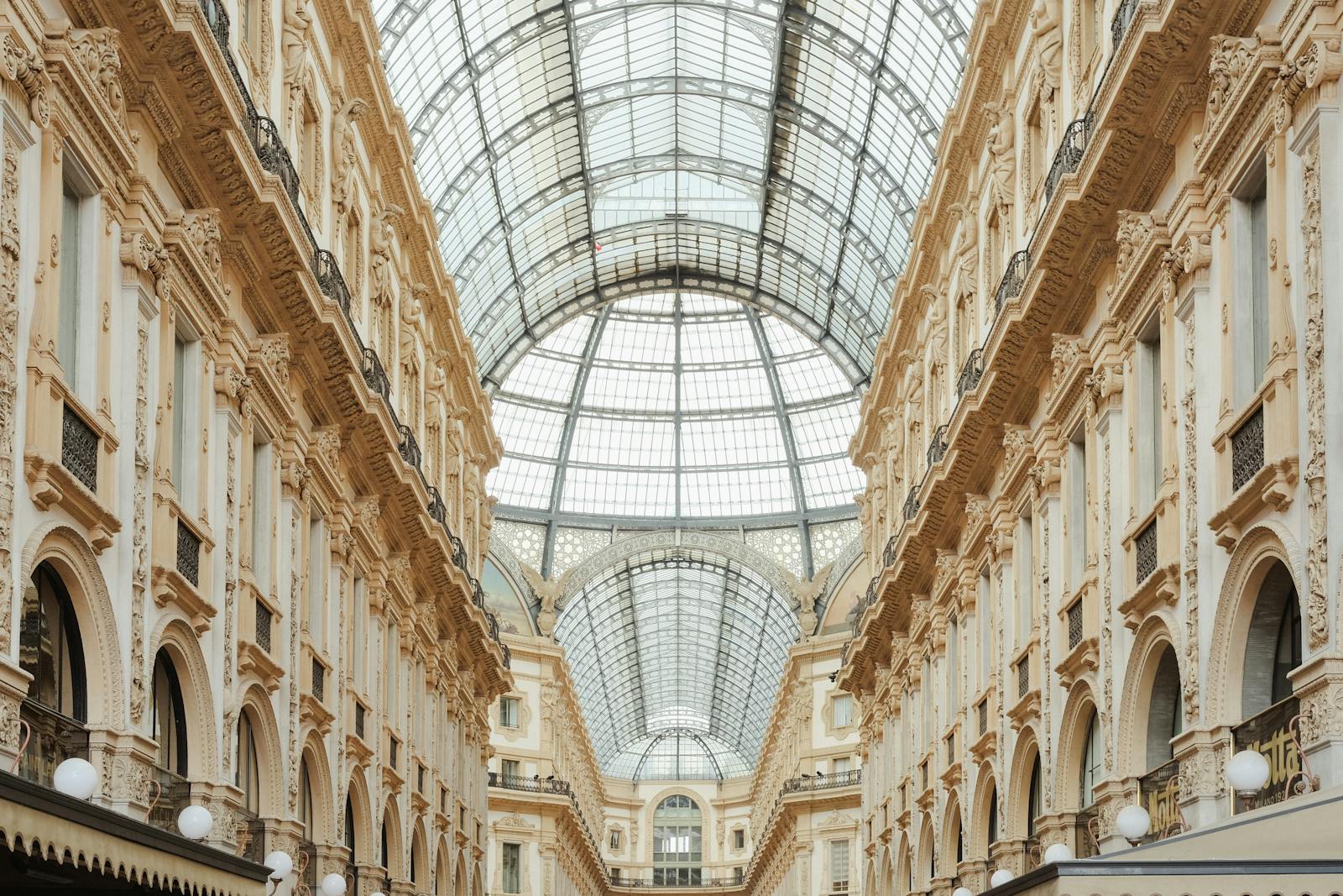 Beautiful view of Galleria Vittorio Emanuele II's interior glass roof and intricate facade in Milan, Italy.